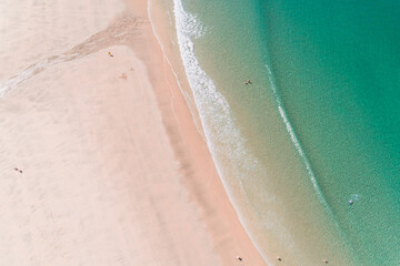 Fototapeta na wymiar Aerial view with drone of a beach in wave of turquoise sea water shot, top view of beautiful white sand background. Holidays concept