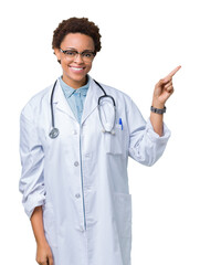 Young african american doctor woman wearing medical coat over isolated background with a big smile on face, pointing with hand and finger to the side looking at the camera.