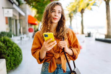 Young woman using smartphone at street. Business, technology, blogging, communication concept.