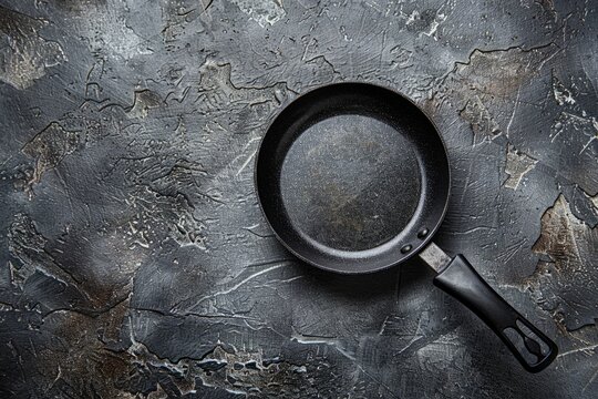 A wide shot of an empty frying pan placed on top of a wooden table