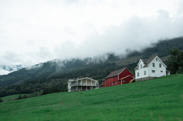 Obraz premium Norway red houses in the mountains it the mist.