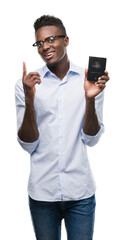 Young african american man holding australian passport surprised with an idea or question pointing finger with happy face, number one