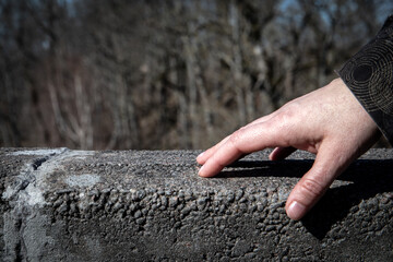 Hand on a stone railing, stone pillars as a support - 781604177