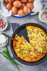 Homemade oven baked frittata with curd cheese, bacon, onion and chives