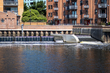 Small waterfall on the canal in the Leeds City Centre showing water falling down from the top rive to the bottom