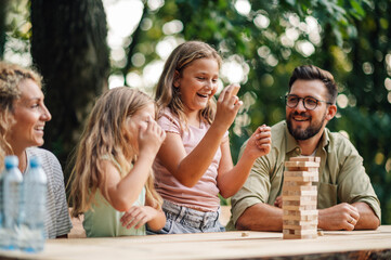 A happy girl made her move while playing jenga with her family.