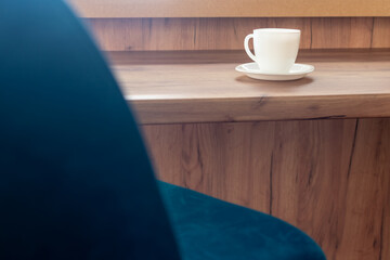 Kitchen cabinet furniture. White tea cup on wooden table close-up with blurred foreground