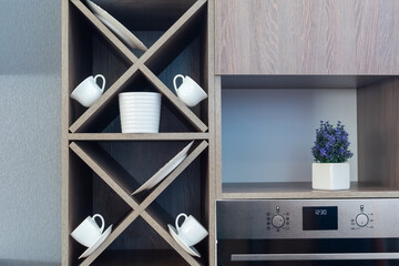 Kitchen cabinet furniture. White cups and plates on shelves kitchen furniture