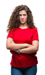Beautiful brunette curly hair young girl wearing casual look over isolated background skeptic and...