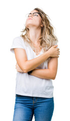 Fototapeta premium Beautiful young blonde woman wearing glasses over isolated background Hugging oneself happy and positive, smiling confident. Self love and self care