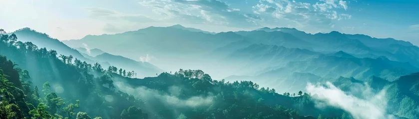 Zelfklevend Fotobehang A breathtaking landscape of mountains enveloped in mist with lush greenery © Creative_Bringer
