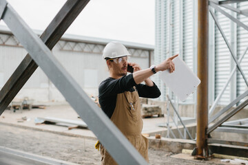 An engineer inspects the construction of grain storage silos. © dsheremeta