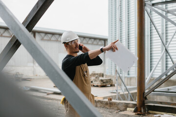 An engineer inspects the construction of grain storage silos.