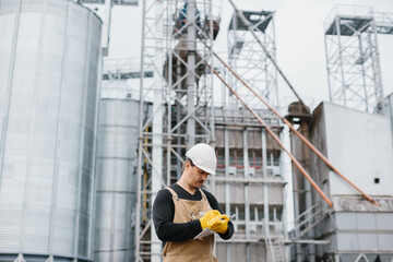 worker at gran silos controlling wheat or corn seeds loading.