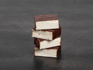 Vanilla souffle in chocolate glaze. Bird's milk. Dark gray background. Close up..