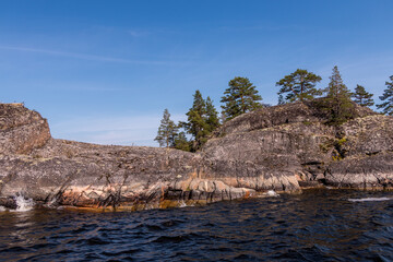 Fototapeta na wymiar Lake Ladoga and rocky islands. Karelian forest, trees growing on rocks. Ladoga skerries. Nordic Scandinavian landscape