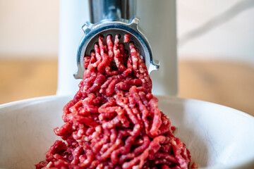 Minced meat and electric meat grinder. Cooking beef minced in the kitchen with an electric grinder