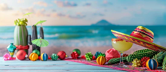 Fotobehang Cinco de Mayo,Mexican colorful summer fiesta party,sombrero hat,maracas margarita cocktail,table colorful Mexican decorations. With the exotic beach "Cinco de Mayo" as a backdrop,mexican banner. © shintartanya