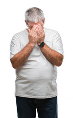 Handsome senior man over isolated background with sad expression covering face with hands while...