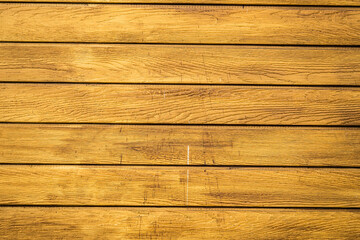 A wooden wall with a grainy texture and a warm, inviting color. The wood appears to be aged and has...