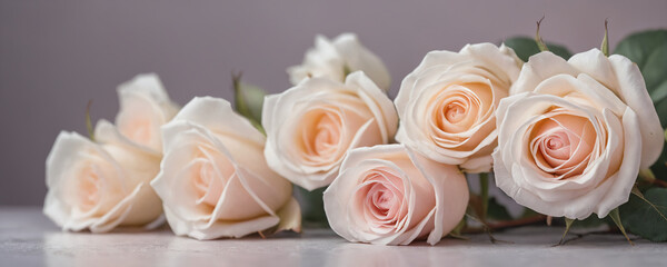 A bouquet of white roses neatly arranged on a table. The delicate flowers are in full bloom and fill the space with a pleasant fragrance.