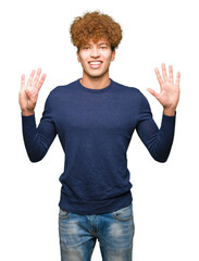 Young handsome man with afro hair showing and pointing up with fingers number nine while smiling...