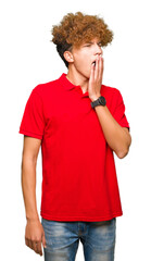 Fototapeta na wymiar Young handsome man with afro hair wearing red t-shirt bored yawning tired covering mouth with hand. Restless and sleepiness.