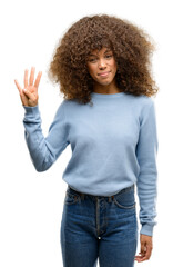 African american woman wearing a sweater showing and pointing up with fingers number four while...