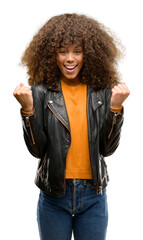 African american woman wearing a leather jacket screaming proud and celebrating victory and success...