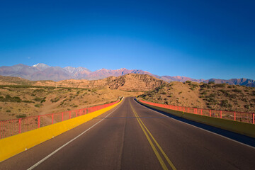 Tarmac road across the desert by the Andes Mountains in Mendoza, Argentina.