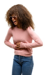African american woman wearing pink sunglasses with hand on stomach because nausea, painful disease...