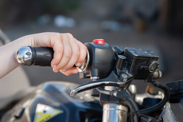 A boy holds the steering wheel of a motorcycle