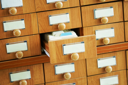 Many closed wooden boxes and one open analog paper file cabinet. Unsigned. Archival repository of information and data Place for inscription - mockup. Photo. Selective focusing