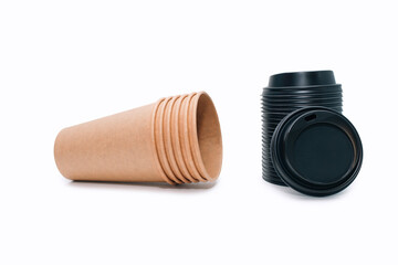 A stack of disposable coffee cups and black plastic lids for them on a white background. Empty cardboard cups that can be recycled. Disposable paper cups - obrazy, fototapety, plakaty