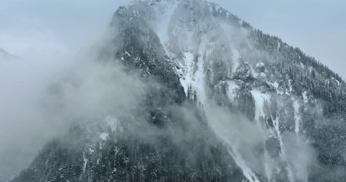Approaching the mountains with pine trees growing on. Mist coating the rock in winter. Mount Rainer national Park, Washington State, the USA.