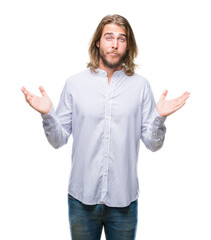 Young handsome man with long hair over isolated background clueless and confused expression with arms and hands raised. Doubt concept.