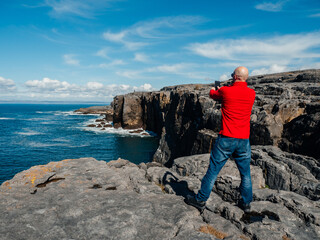 Tourist standing and enjoy view of stunning mini cliff in county Clare, Ireland. Travel and...