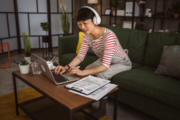 Japanese woman work at home with laptop and hold document