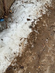 Melting dirty snow on the streets of the city during the daytime in winter. Snow with sand and mud lies on the road.