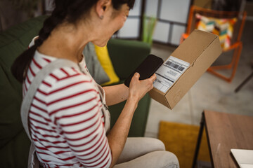 Japanese woman check box of received package or product at home