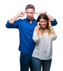 Young couple in love over isolated background covering ears with fingers with annoyed expression...