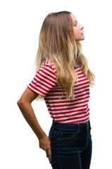 Young beautiful blonde woman over isolated background looking to side, relax profile pose with natural face with confident smile.