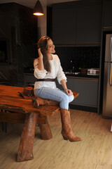 jovem mulher estilo vaqueira cowtry em cozinha planejada com mesa rustica de madeira 