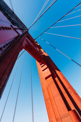 Majestic architecture of the Golden Gate Bridge captured from the roadway, clear blue sky in the background - 781647729