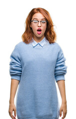 Young beautiful woman over isolated background wearing winter sweater afraid and shocked with surprise expression, fear and excited face.