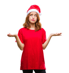 Young beautiful woman over isolated background wearing christmas hat clueless and confused...
