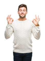 Young handsome man wearing winter sweater over isolated background relax and smiling with eyes closed doing meditation gesture with fingers. Yoga concept.