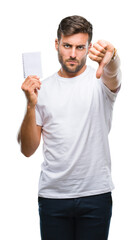 Young handsome man holding notebook over isolated background with angry face, negative sign showing...