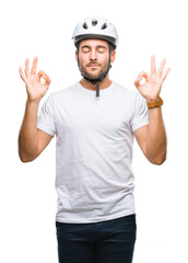 Young handsome man wearing cyclist safety helmet over isolated background relax and smiling with eyes closed doing meditation gesture with fingers. Yoga concept.