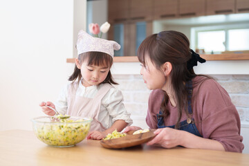 サラダを盛り付ける親子　女の子とお母さん - 781652710